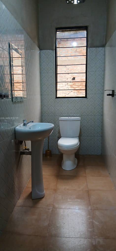 Tiled bathroom with a washbasin, toilet and window